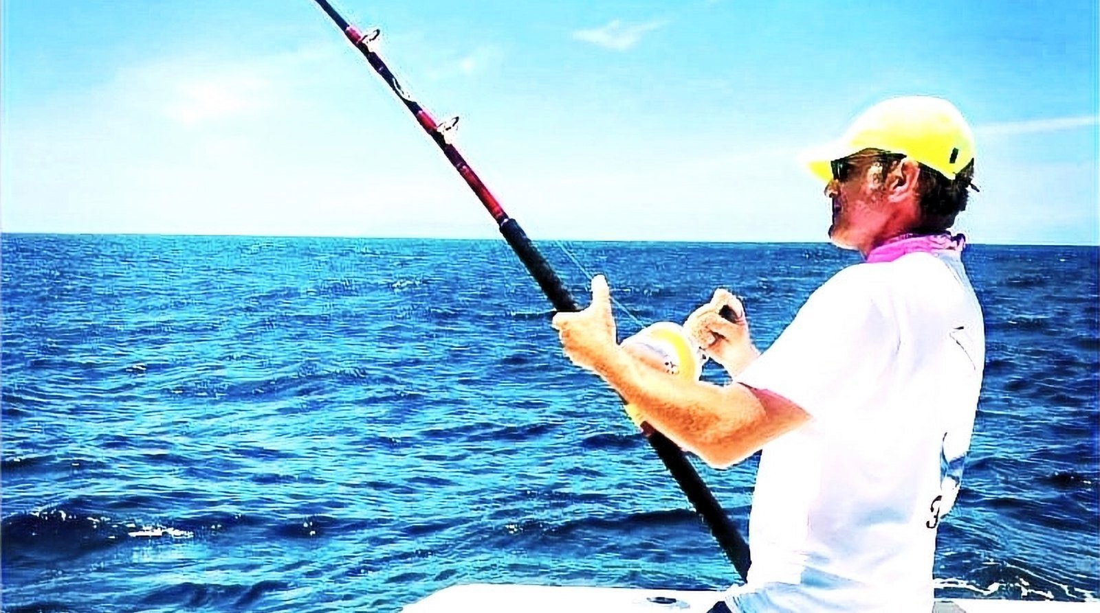 Angler with a bent rod fighting a fish from the bow of a boat on Banderas Bay, Puerto Vallarta
